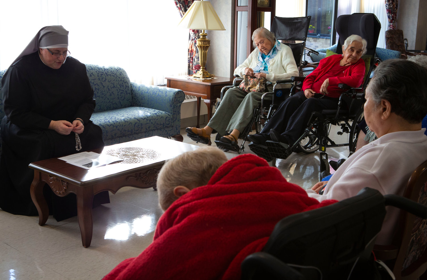 Sister Constance Veit, a Little Sister of the Poor, prays the rosary March 25, 2019, with elderly residents of the Jeanne Jugan Residence for senior care in Washington. Sister Constance is considered a spiritual mother by many of the residents, who said they will honor her on Mother’s Day.